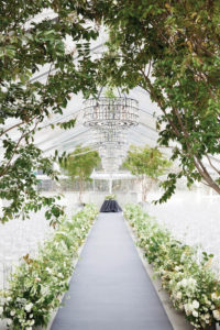 This stunning design by Seattle’s Sinclair & Moore Events incorporated light and natural elements to create an ethereal setting for this wedding ceremony. Clear acrylic chairs, swaths of greenery and mirrored chandeliers took advantage of the natural light. Design and planning by Sinclair & Moore Events. Rentals by CORT Party Rental. Photo by Belathée Photography. 