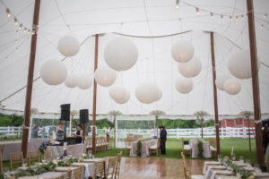 Wood dance floors, stained wood poles and café lighting are inventory must-haves for rustic weddings. Photo courtesy of Blue Peak Tents.