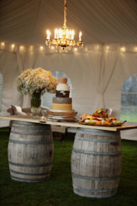 Wine barrels and an old door create a rustic catering station for this wedding reception in Ferndale, Wash., produced by Sinclair & Moore Events. Photo by Michèle M. Waite Photography, courtesy of CORT Party Rental.
