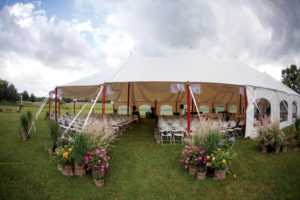 This custom Bayview 44-by-104-foot sailcloth tent from Charnecke Tents is installed for a summer wedding. Charnecke also manufactured the interior swags. Photo by ZoroPhoto.