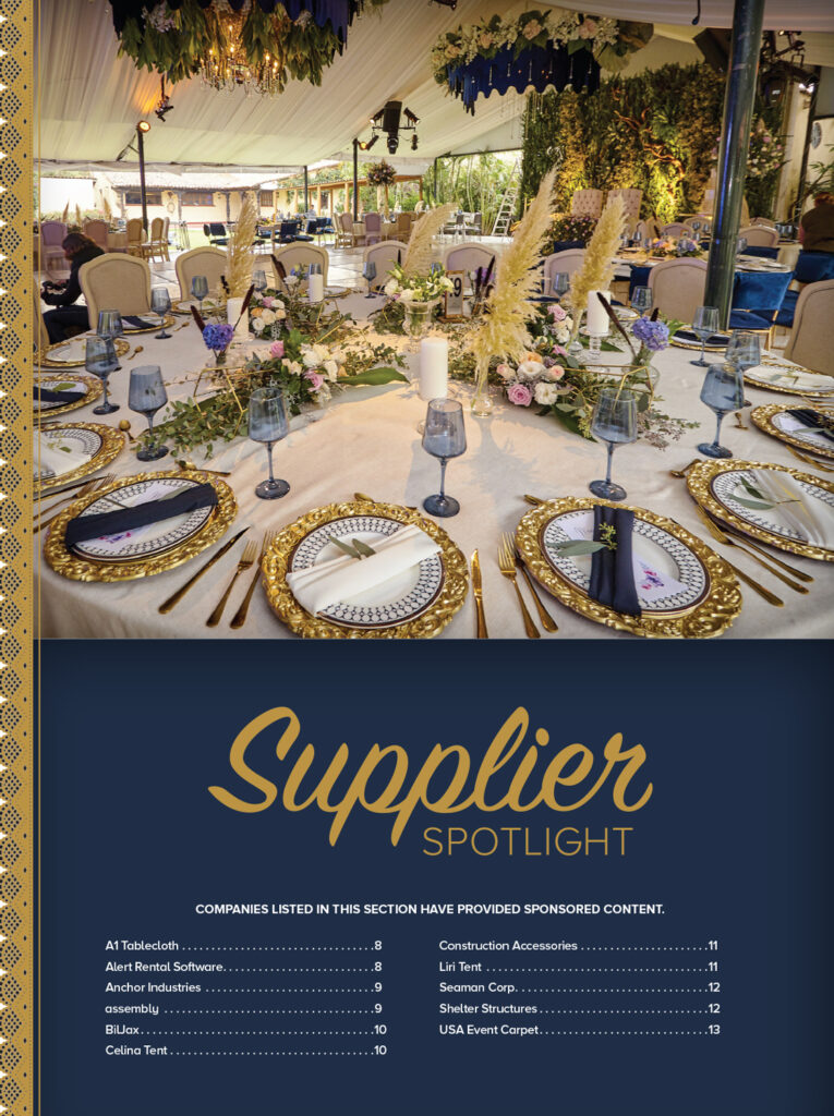 Elegant dining setup under a tent, featuring golden-rimmed plates, floral decorations, blue glasses, and a sophisticated color palette.